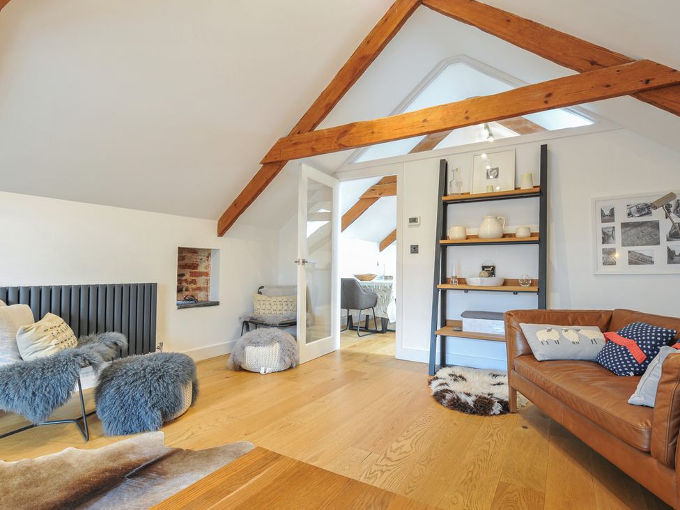 A living room with a sofa and shelving unit at The Dairy in 