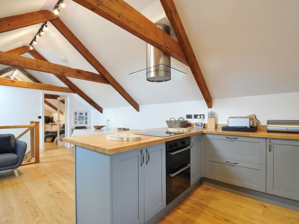 A kitchen with a stove and kitchen island at The Dairy in 