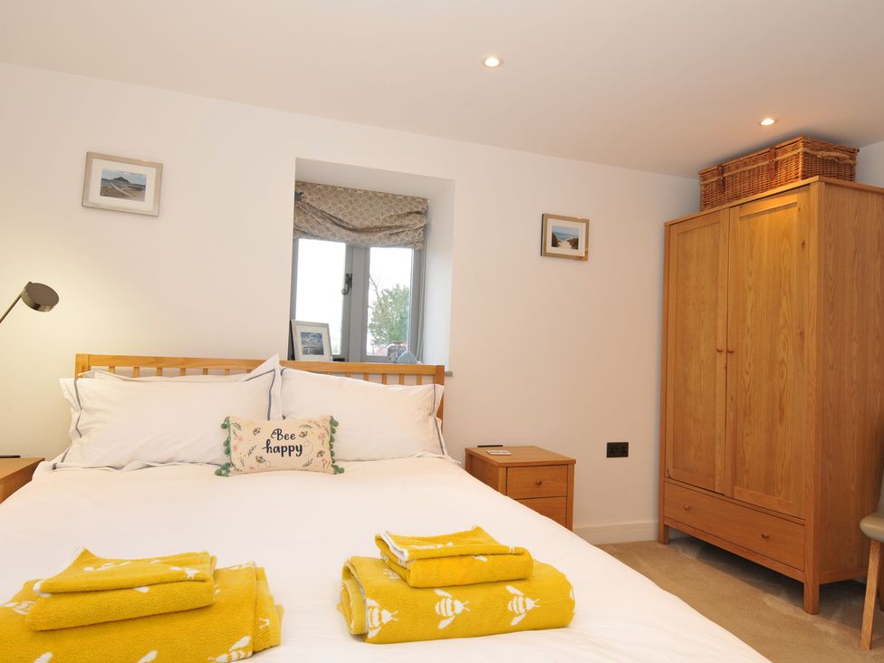 A bedroom with a bed and wardrobe at The Dairy in 