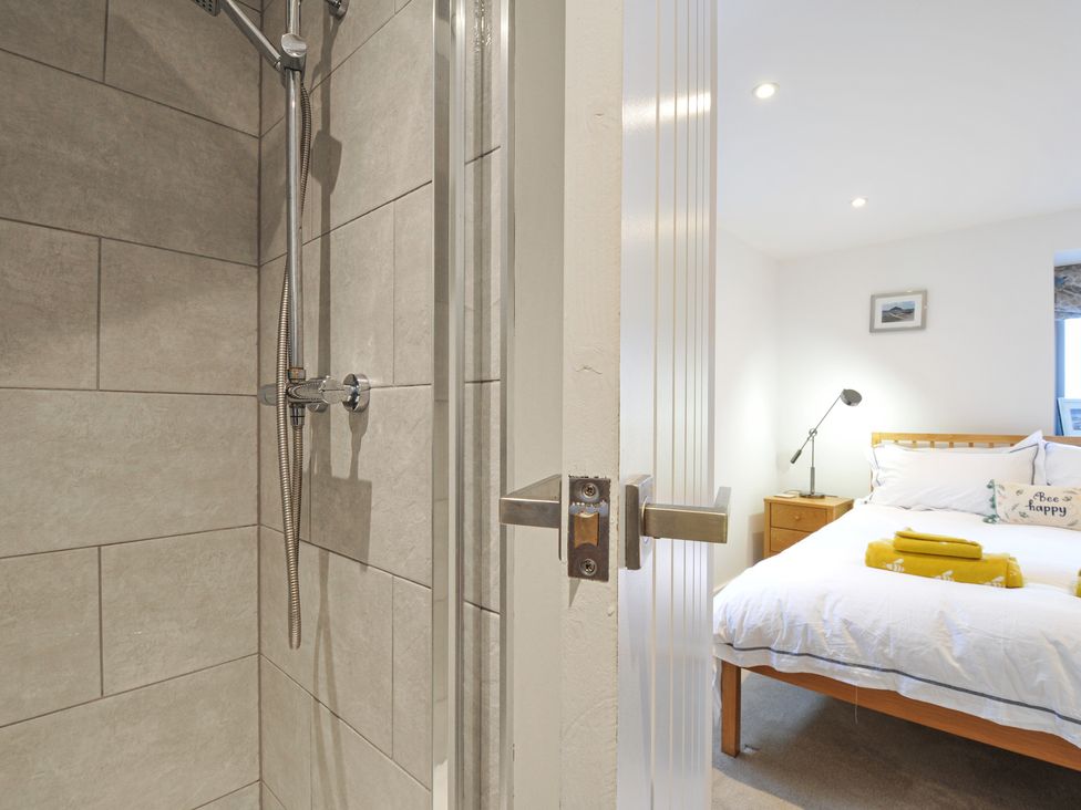 A shower area with tiles and a bedroom visible at The Dairy 