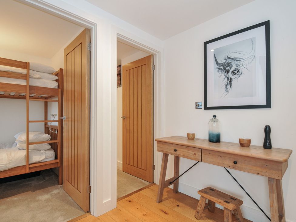 A bedroom with a bunk bed and wooden table at The Dairy in 