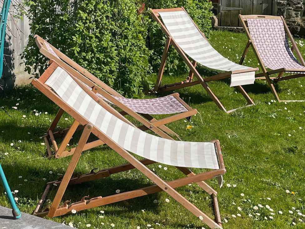 Deck chairs on grass in a garden at The Dairy in Bridgerule
