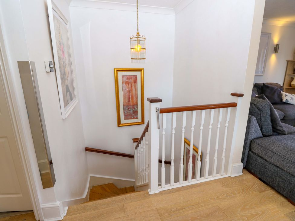 A staircase with a light fixture and artwork at Riverview in Hamble