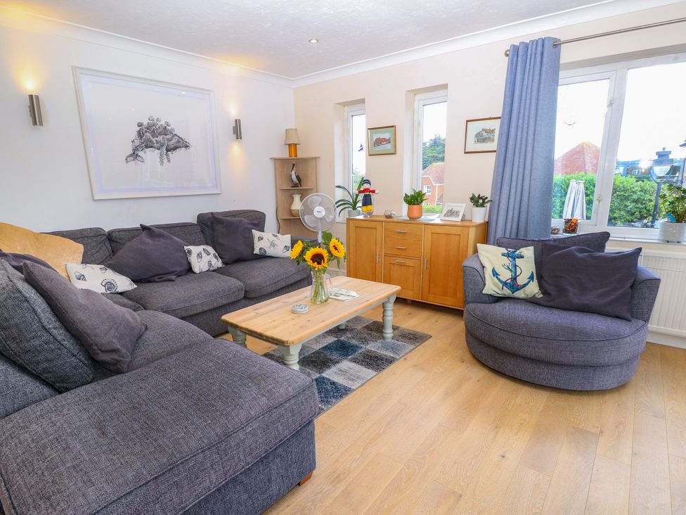 A living room with a sofa, armchair, and coffee table at Riverview in Hamble