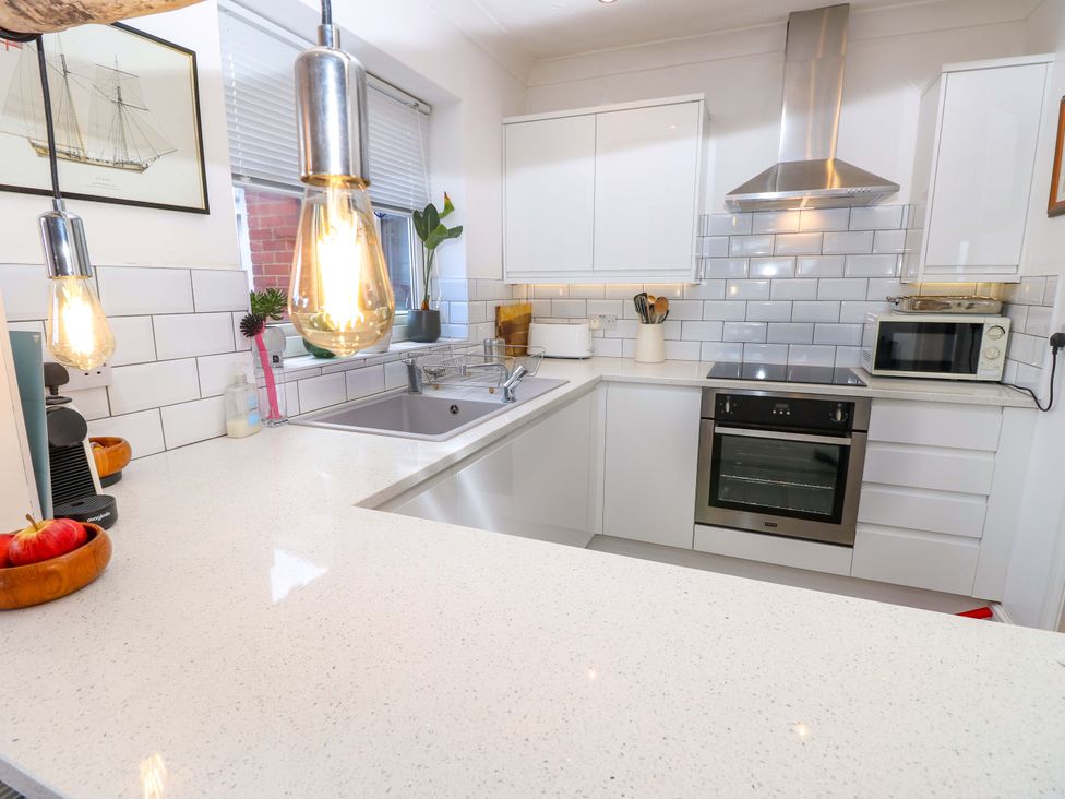 A kitchen with white cabinets and appliances at Riverview in Hamble