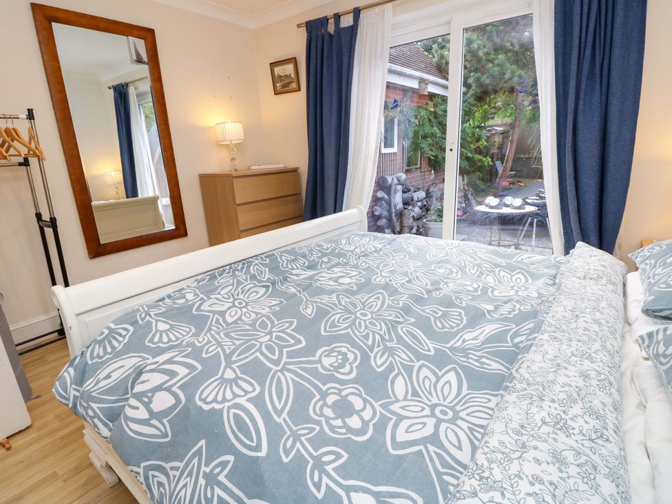 A bedroom with a bed and mirror at Riverview in Hamble