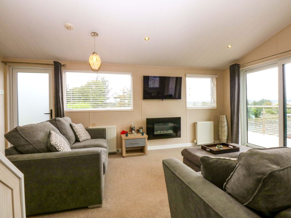 A living room with a sofa and television at The Hideaway in Pwllheli