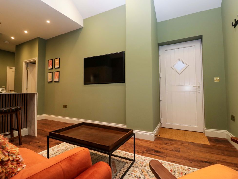 A living room with a television and a door at The Studio in Windermere