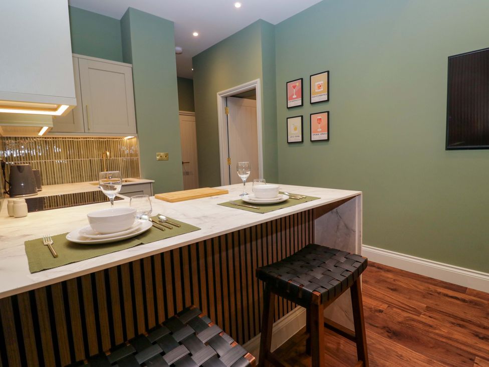 A kitchen with dining table and stools at The Studio in Windermere