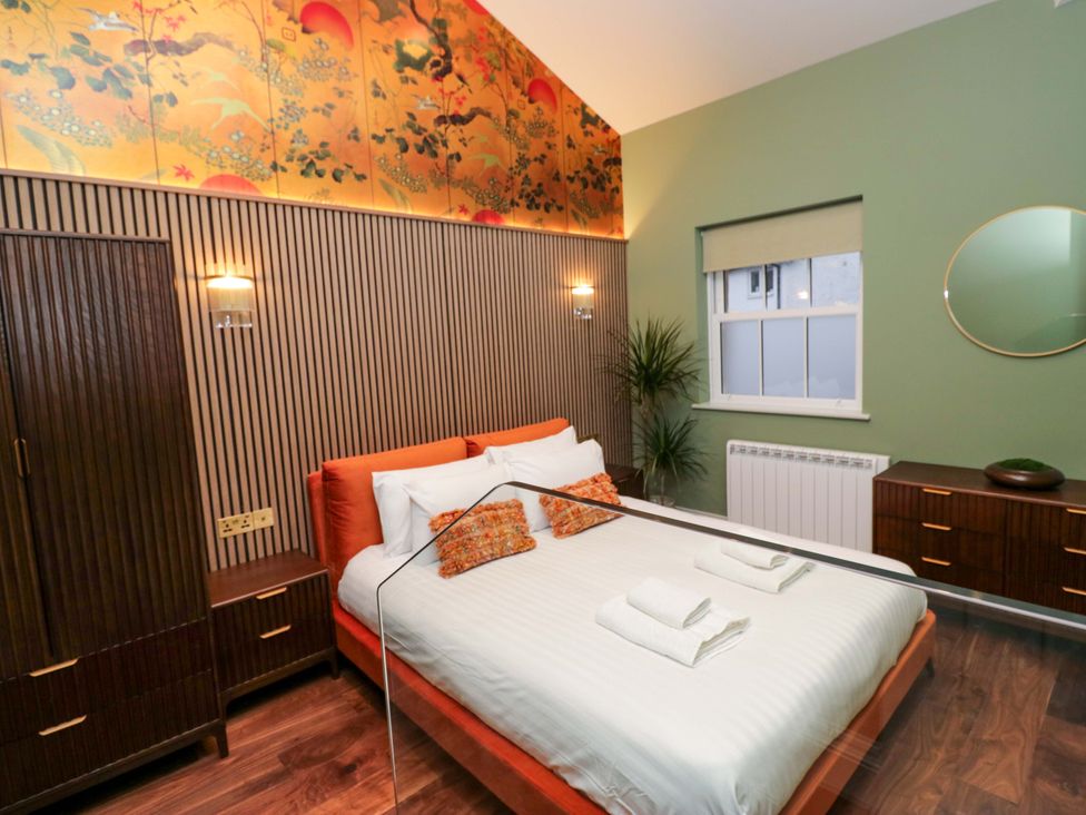 A bedroom with a bed and wardrobe at The Studio in Windermere