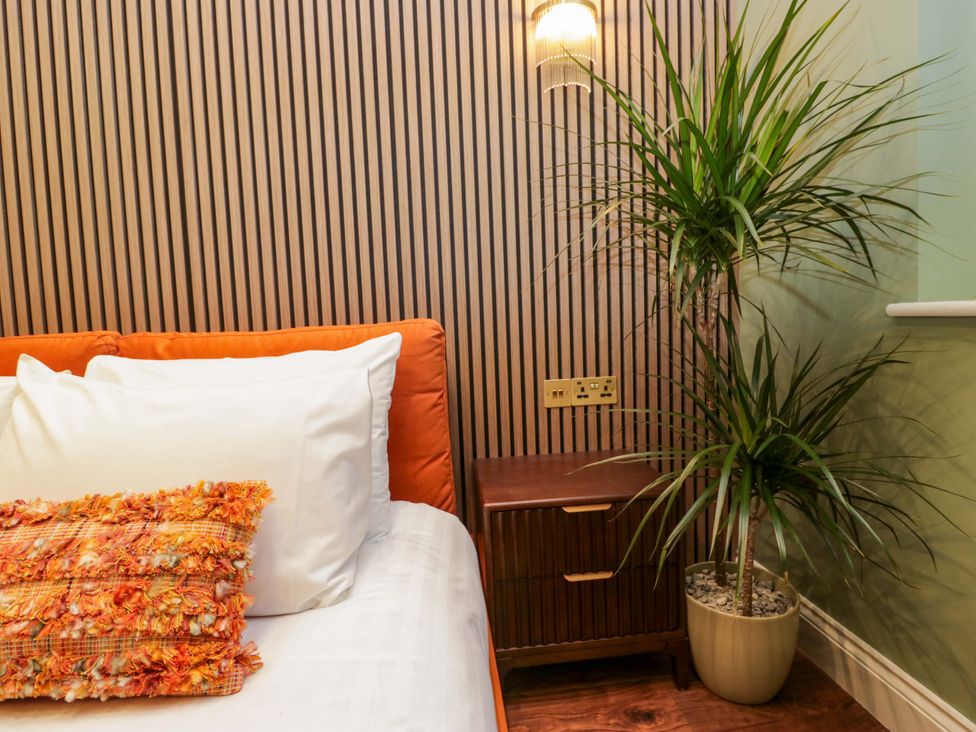 A bedroom with a sofa and a plant at The Studio in Windermere