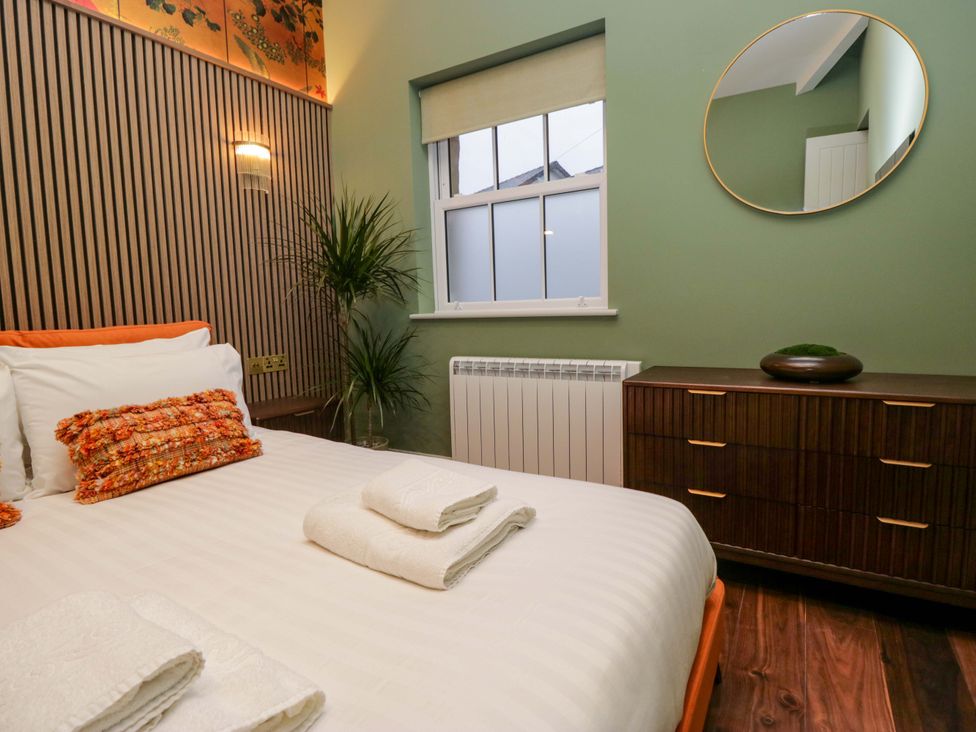 A bedroom with a bed and dresser at The Studio in Windermere