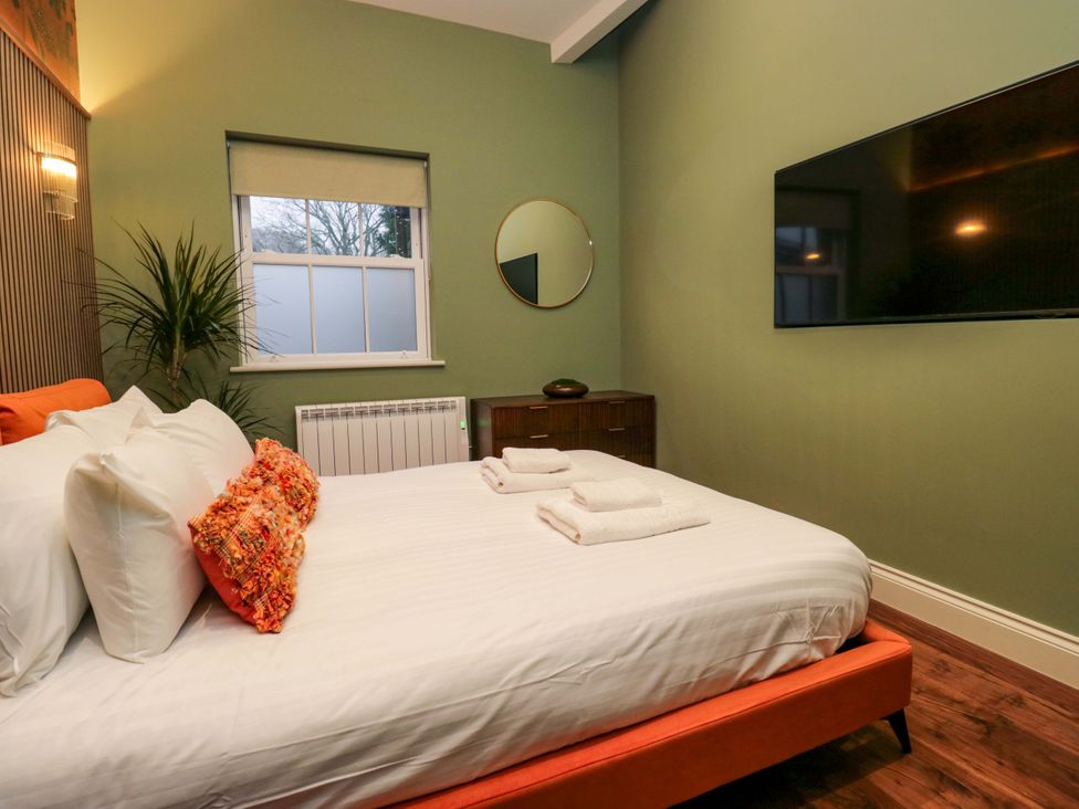 A bedroom with a bed and television at The Studio in Windermere