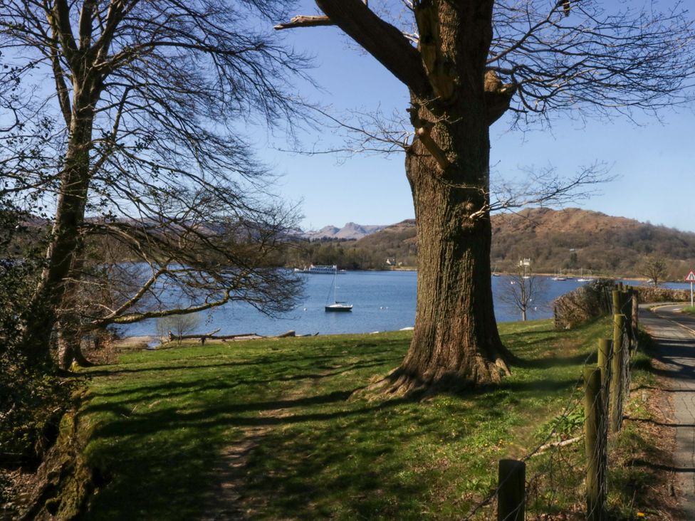 A lake with mountains in the background and a boat at The Studio in Windermere