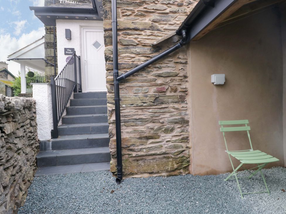 An outdoor area with stairs and a green chair at The Studio in Bowness-On-Windermere
