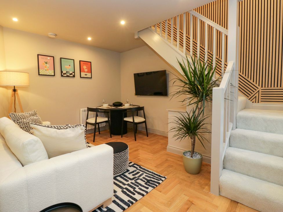 A living room with a dining table and sofa at The Coach House in Windermere