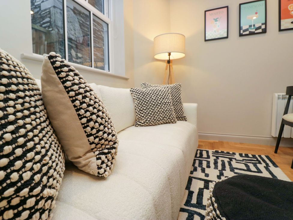 A living room with a sofa and cushions at The Coach House in Windermere