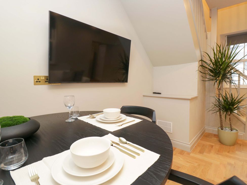 A dining room with a table set for meals at The Coach House in Windermere