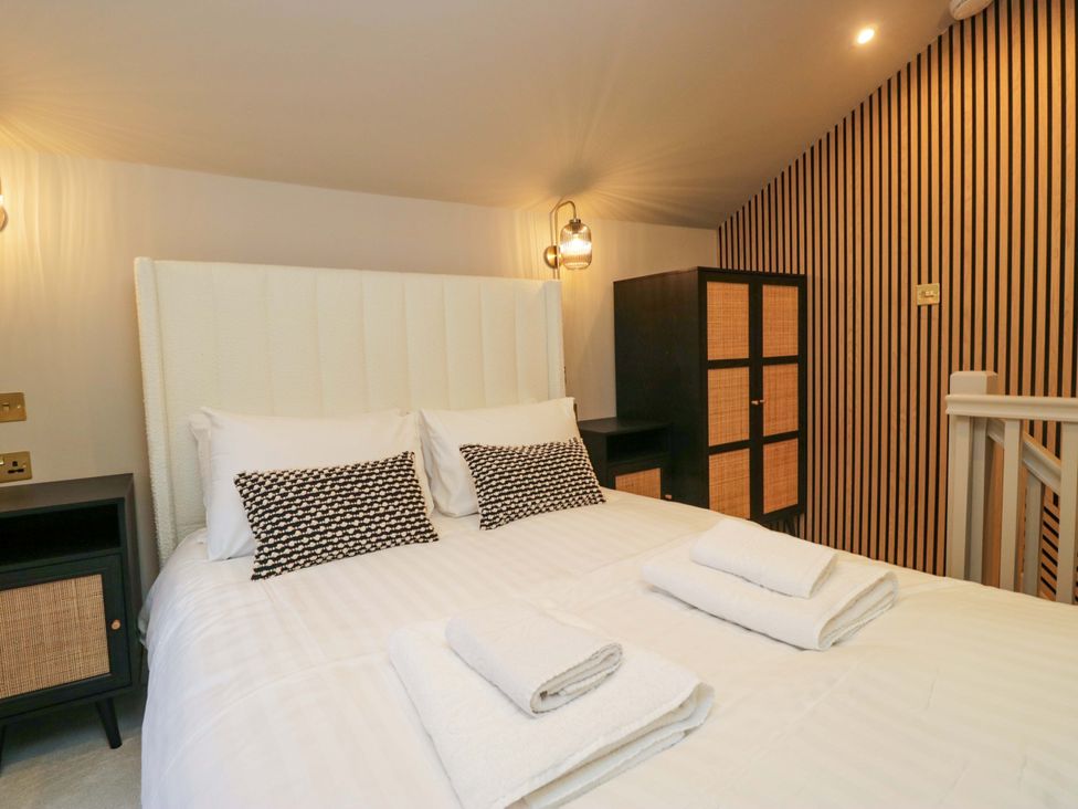 A bedroom with a bed and a wardrobe at The Coach House in Windermere