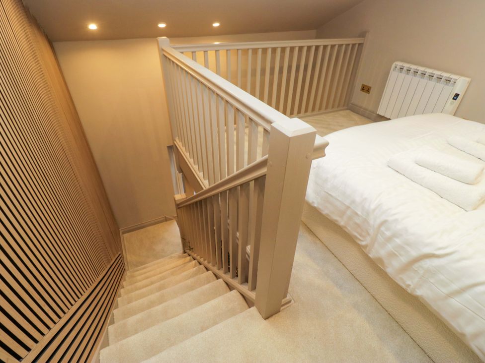 A bedroom with a staircase and banister at The Coach House in Windermere