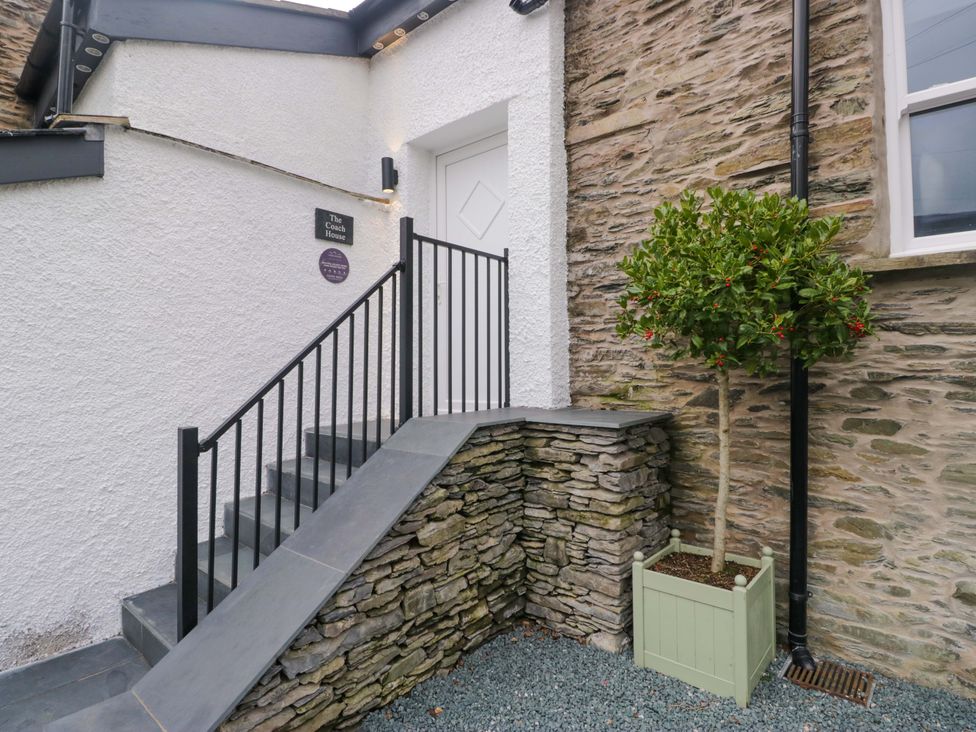 An entrance with a staircase leading to a door at The Coach House in Bowness-On-Windermere
