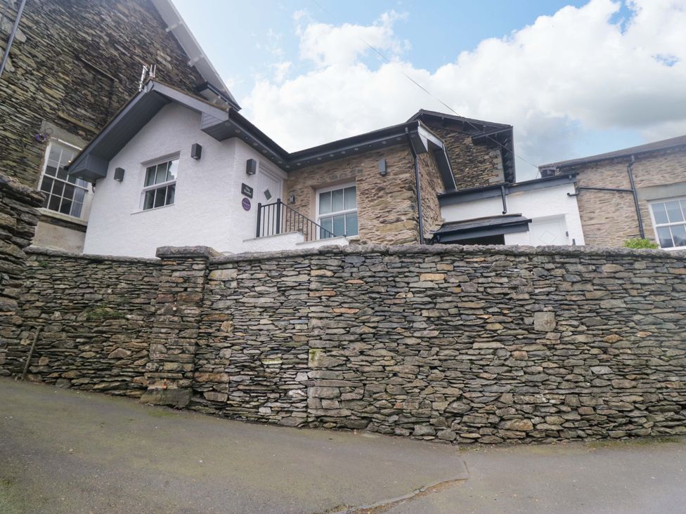 A building with windows and a stone wall at The Coach House Bowness-On-Windermere