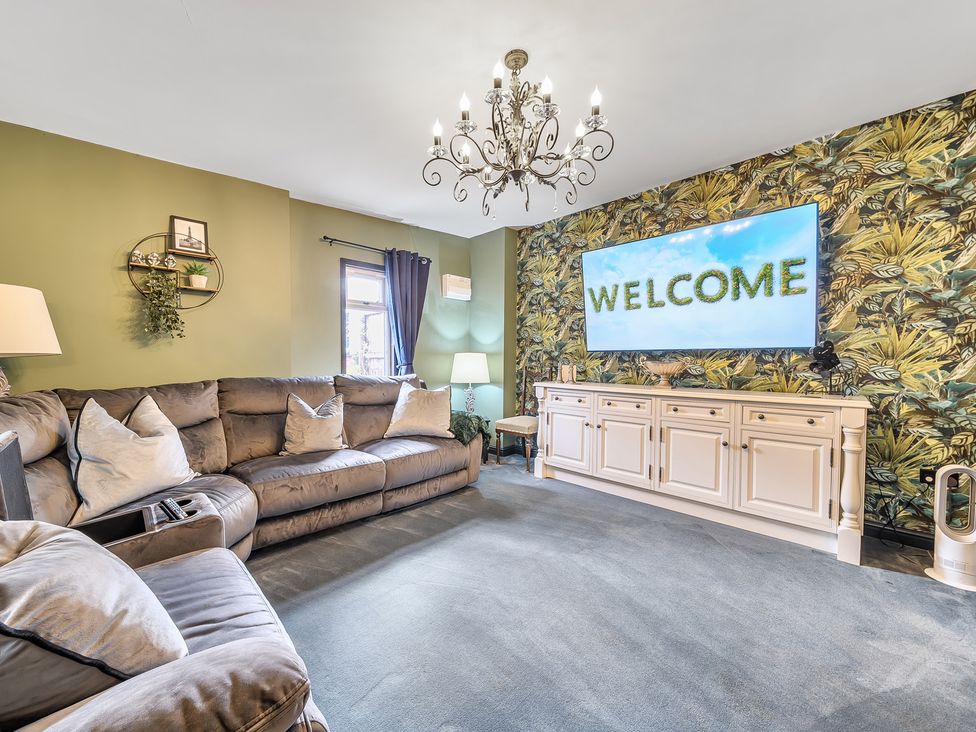 A living room with a sofa and television at The Stables in Poulton-le-Fylde