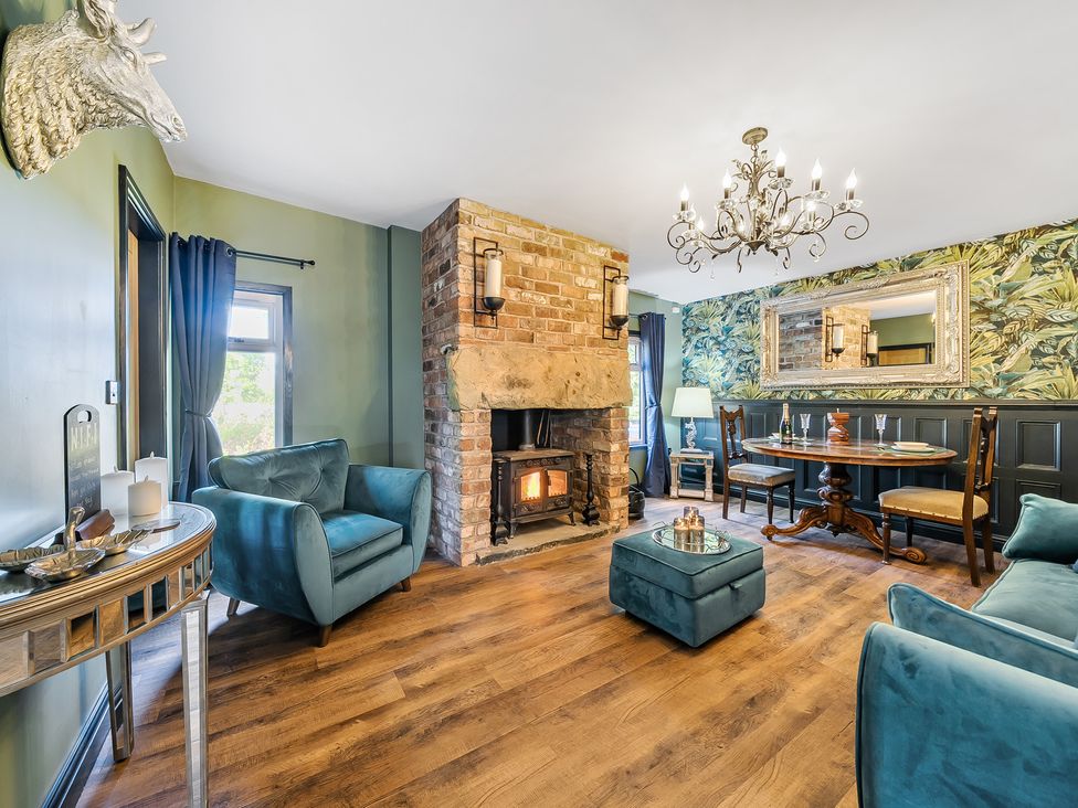 A living room with a fireplace and table at The Stables in Poulton-le-Fylde