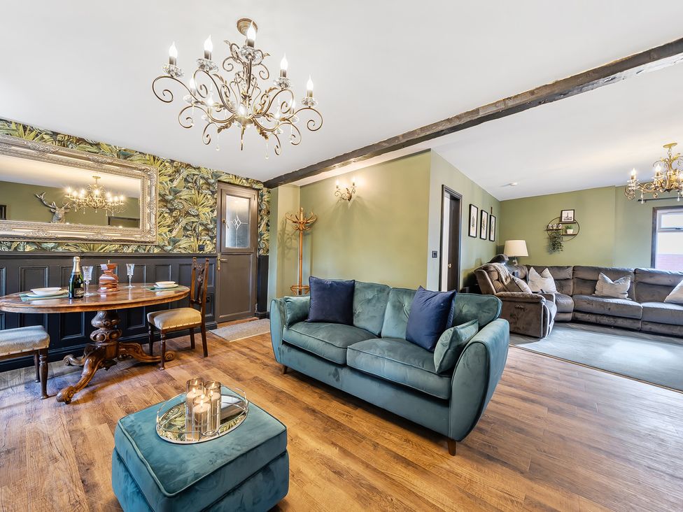 A living room with a sofa and dining area at The Stables in Poulton-le-Fylde