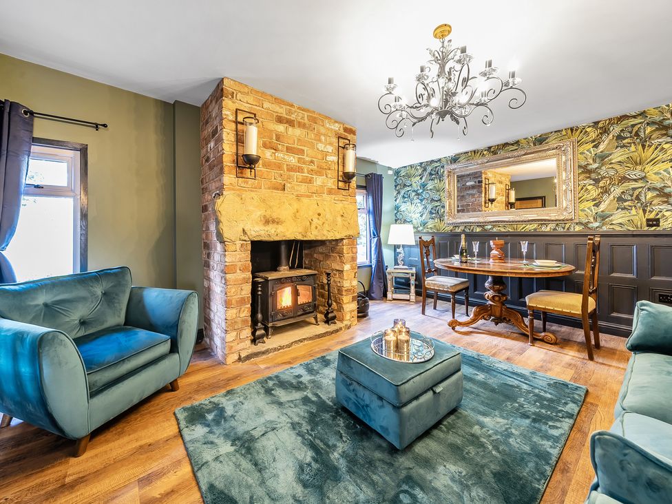 A living room with a fireplace and dining area at The Stables in Poulton-le-Fylde