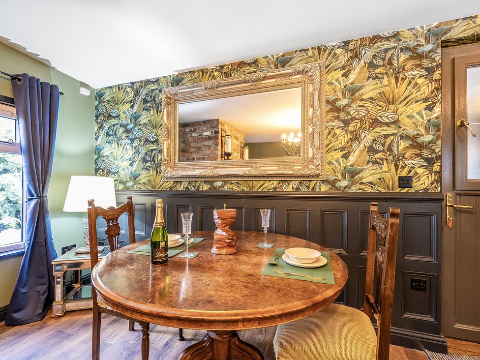 A dining room with a round table and champagne at The Stables in Poulton-le-Fylde