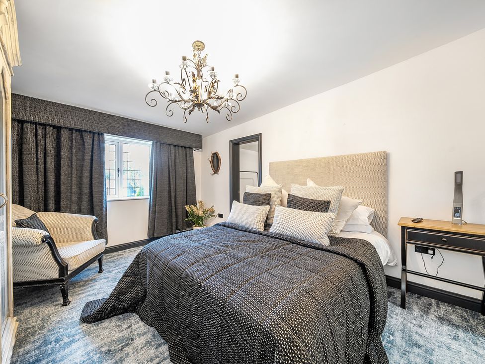 A bedroom with a bed and chair at The Stables in Poulton-le-Fylde