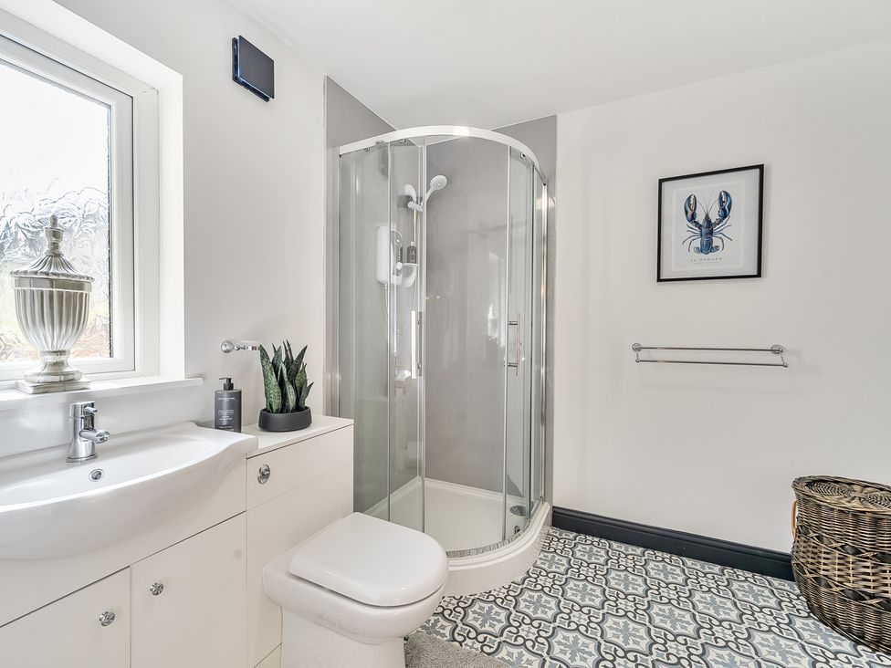 A bathroom with a shower and wash basin at The Stables in Poulton-le-Fylde