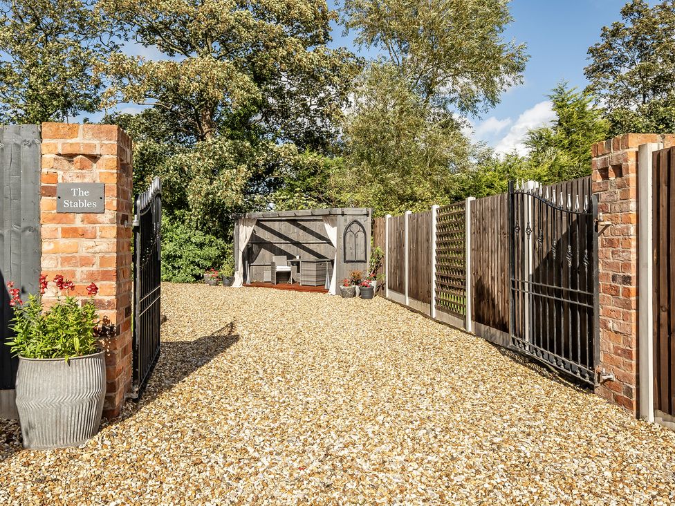 A garden entrance with gravel path and seating area at The Stables in Poulton-le-Fylde