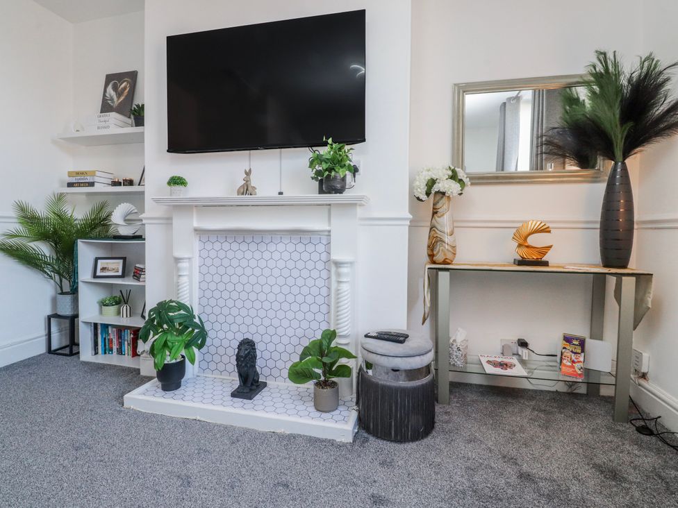 A living room with a television above a fireplace at Bliss in Lytham St. Annes