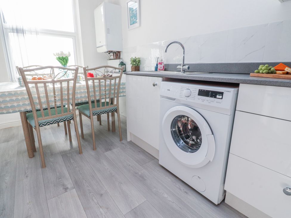 A kitchen with a washing machine and table at Bliss in Lytham St. Annes