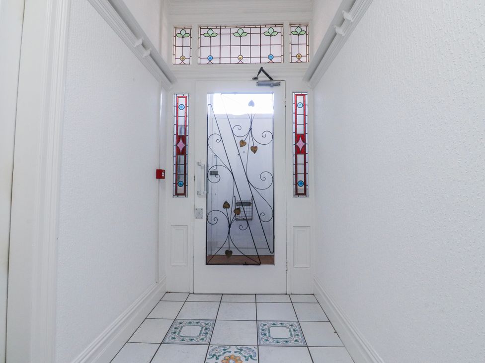 A hallway with a front door and stained glass windows at Bliss in Lytham St. Annes