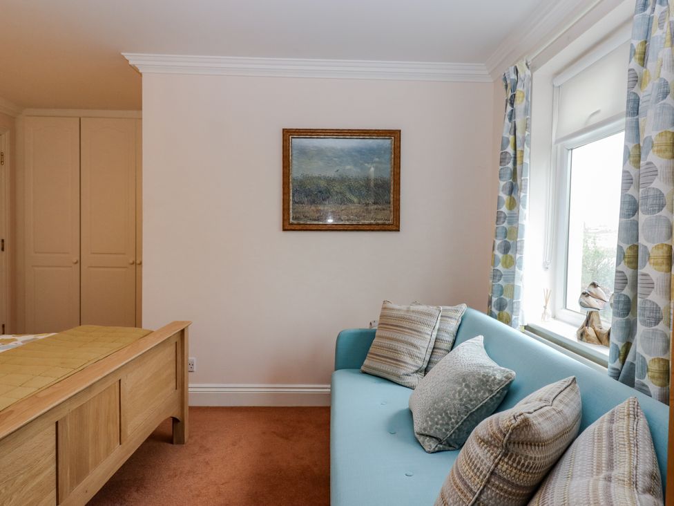 A living room with a sofa and a painting at 8 Thurlestone Rock in Kingsbridge