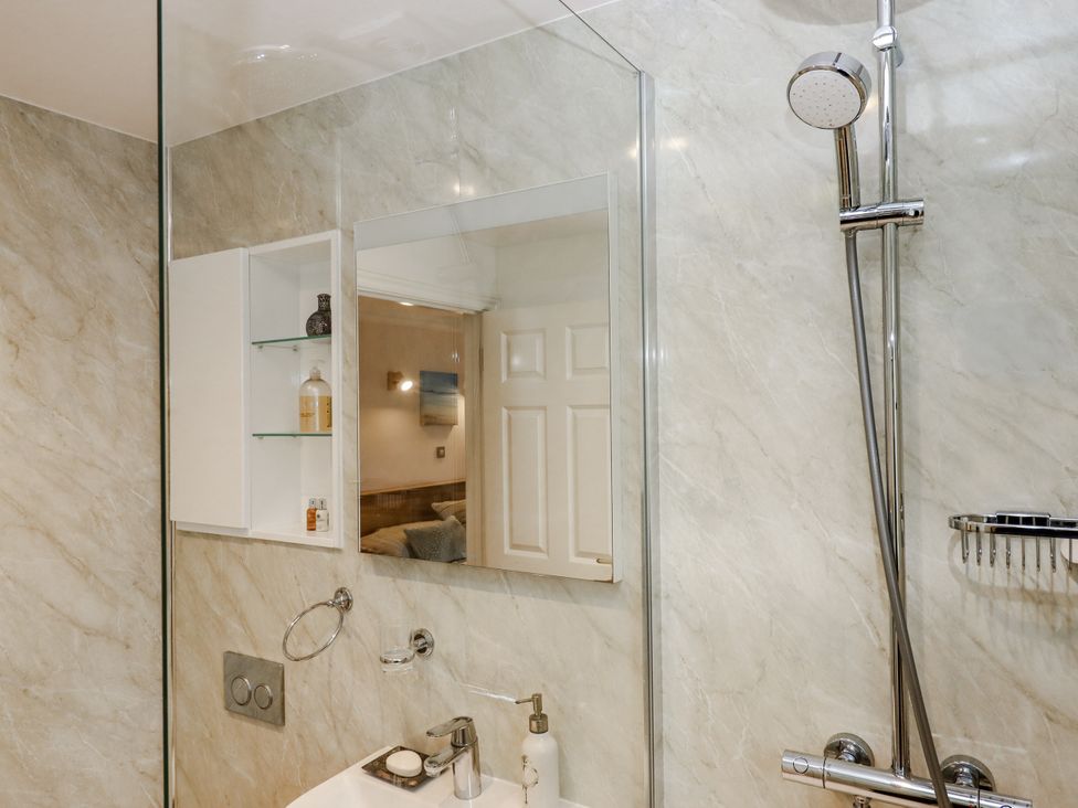 A bathroom with a shower and mirror at 8 Thurlestone Rock in Kingsbridge