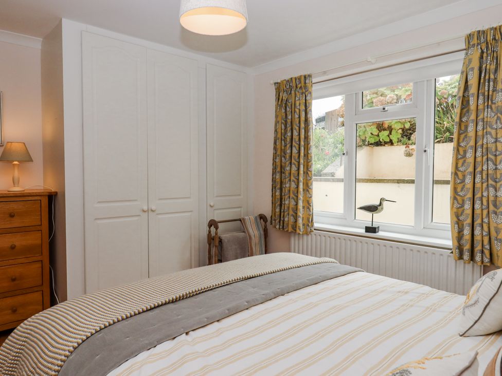 A bedroom with a bed and dresser at 8 Thurlestone Rock in Kingsbridge