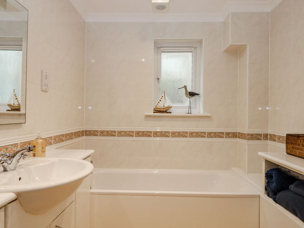 A bathroom with a bathtub and sink at 8 Thurlestone Rock in Kingsbridge