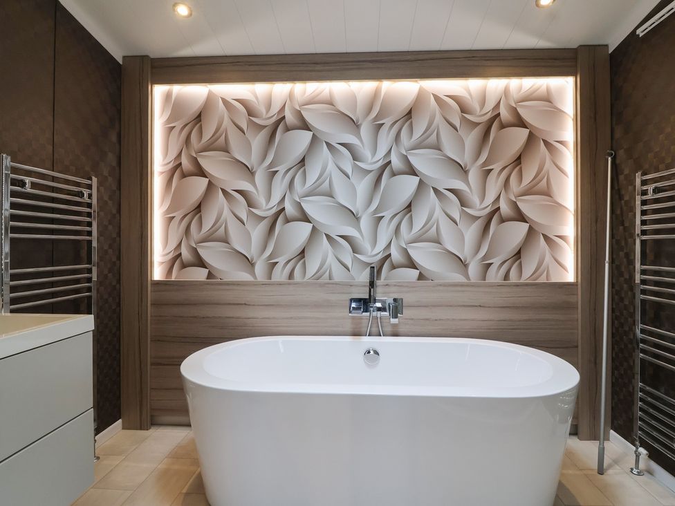 A bathroom with a bathtub and wall design at Whistler in Wimborne
