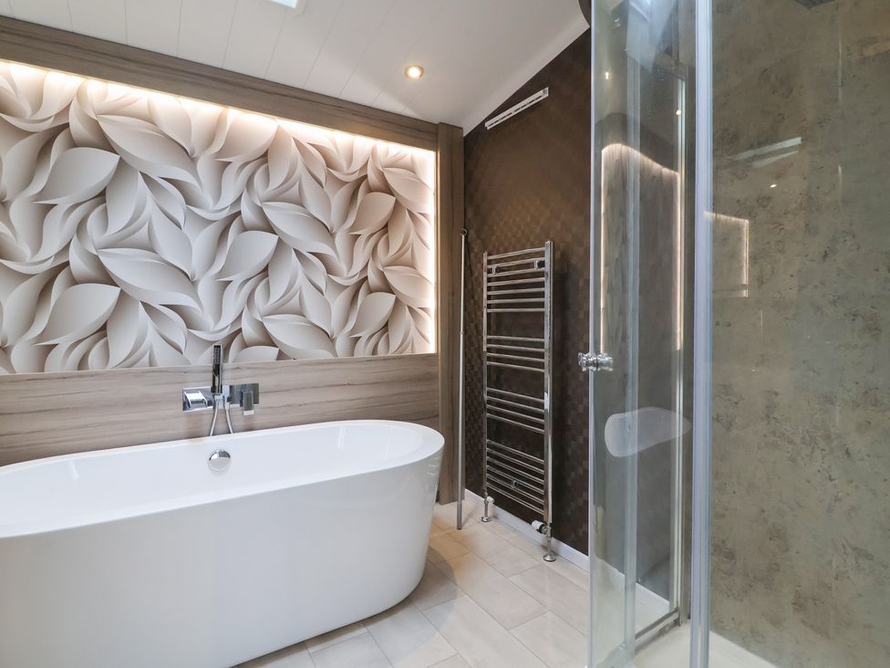 A bathroom with a bathtub and shower at Whistler in Wimborne