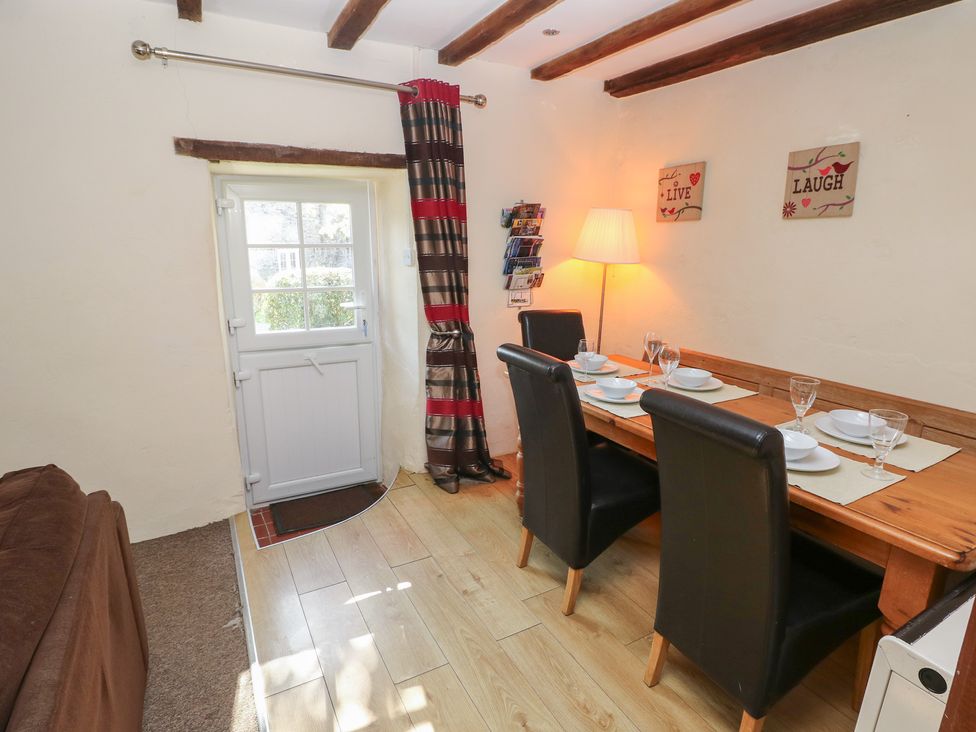 A dining room with a wooden table and chairs at Carthouse Cottage Clarbeston Road