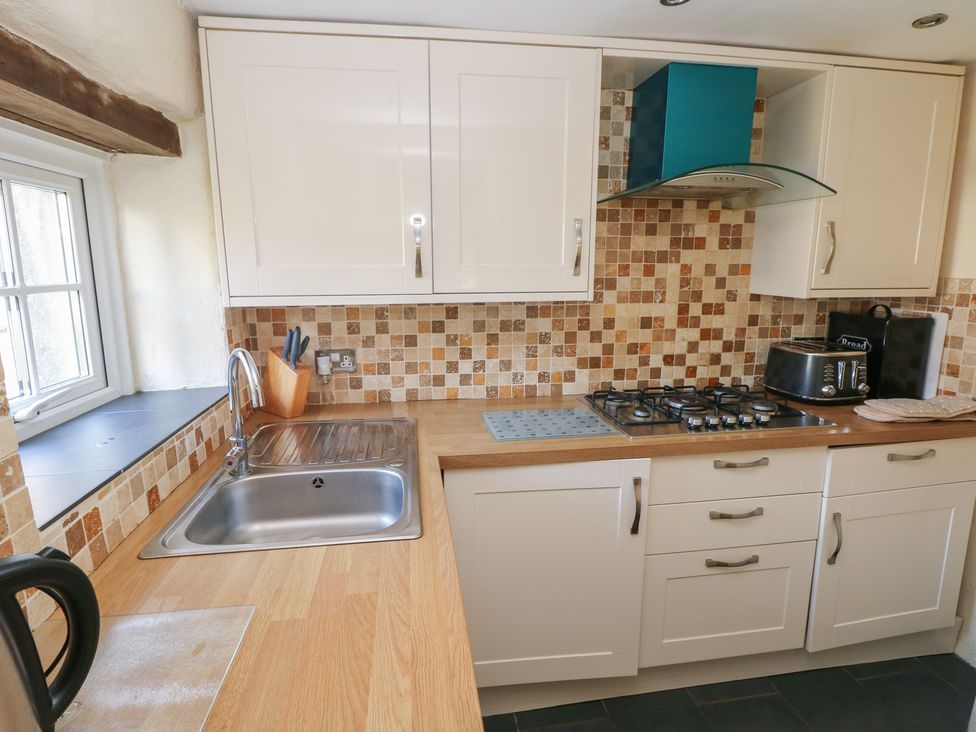 A kitchen with cabinets and appliances at Carthouse Cottage in Clarbeston Road