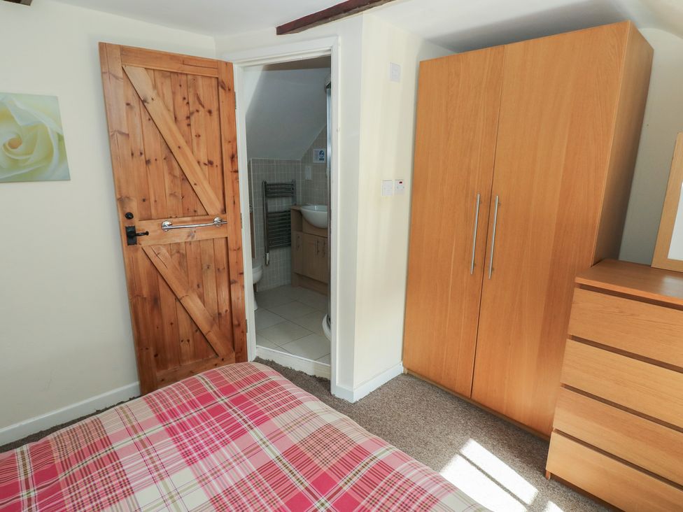 A bedroom with a bed and wardrobe at Carthouse Cottage in Clarbeston Road