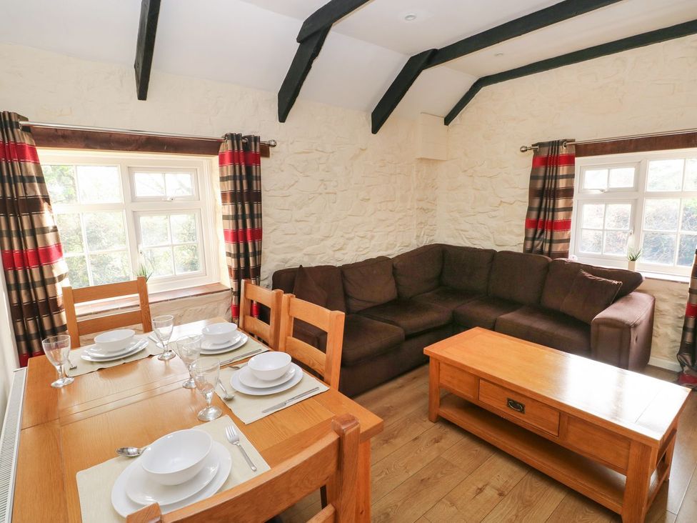 A living room with a dining table set and a sofa at Knap Cottage in Clarbeston Road