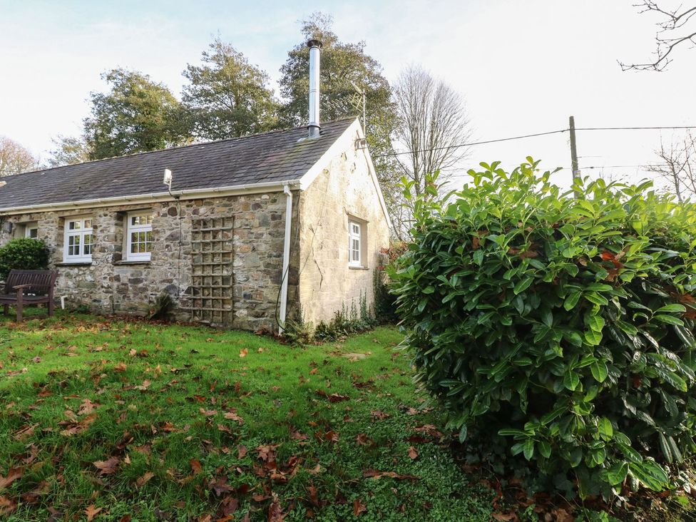 An outdoor view of a stone cottage with a garden at Knap Cottage in Clarbeston Road