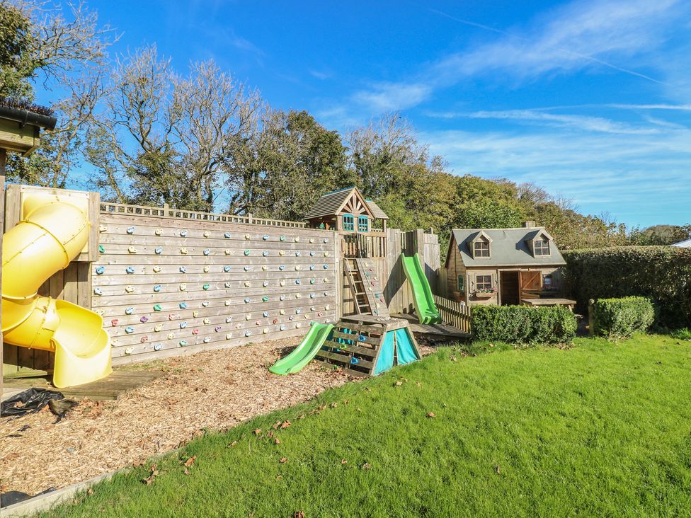 A playground with a slide and climbing wall in Knap Cottage in Clarbeston Road