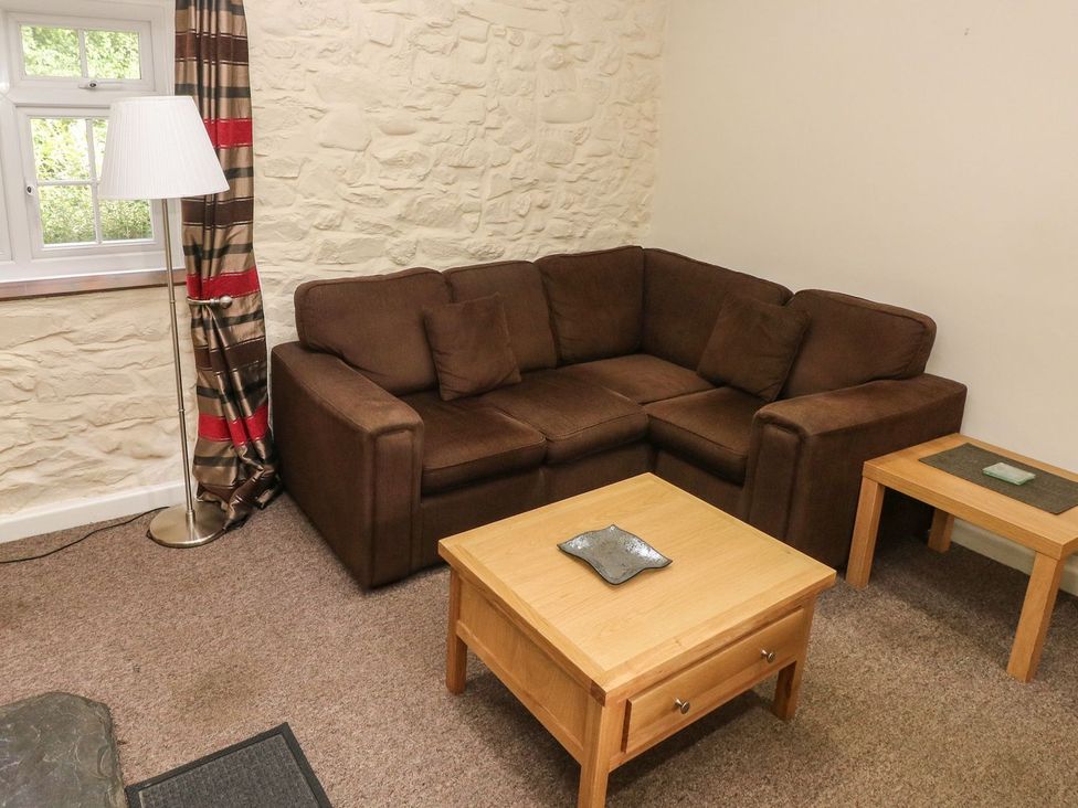 A living room with a sofa and table at Corner Cottage in Clarbeston Road